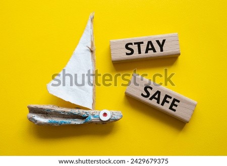 Stay Safe symbol. Concept word Stay Safe on wooden blocks. Beautiful yellow background with boat. Business and Stay Safe concept. Copy space