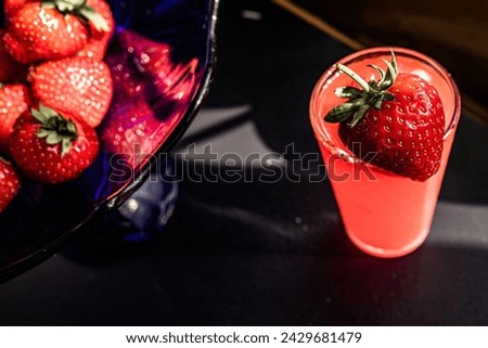 Strawberry juice in a glass on a black background. strawberry and blueberry punch, accompanied by peonies, a colorful concoction perfect for any celebration.. Sweetness and sophistication concept Royalty-Free Stock Photo #2429681479