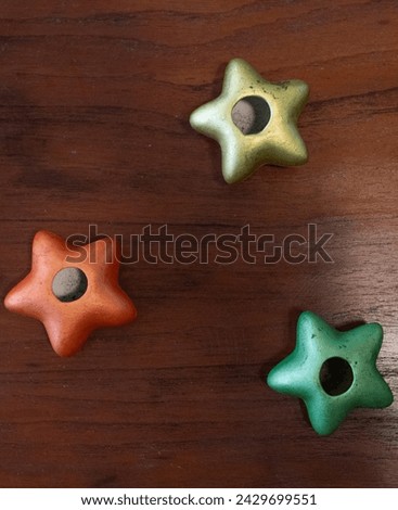 Close-up image of three different colors stars decorations on a dark wood background