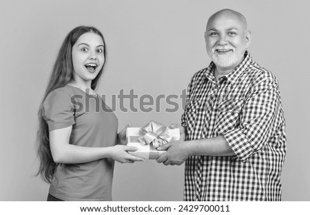 amazed kid and granddad with present box for anniversary