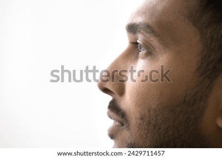 Close up profile photo of handsome serious Indian man on white gray studio background. Guy having attractive appearance, groomed beard look into distance, thoughts, ponders, memories, eyesight, vision Royalty-Free Stock Photo #2429711457