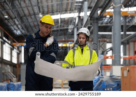 Male and female rail engineer working with blueprint drawing in electric train garage  Royalty-Free Stock Photo #2429755189