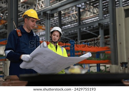Male and female rail engineer working with blueprint drawing in electric train garage  Royalty-Free Stock Photo #2429755193