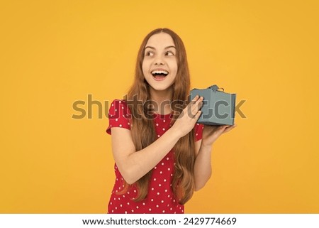 Excited face, cheerful emotions of teenager girl. Child teen girl 12-14 years old with gift on yellow isolated background. Birthday party, holiday present concept.