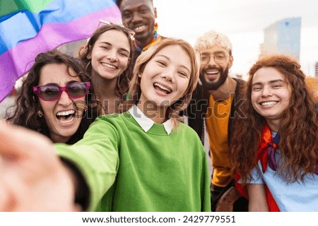 Asian woman taking selfie photo of diverse friends having fun with LGBT gay rainbow flags Royalty-Free Stock Photo #2429779551