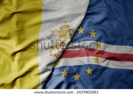 big waving national colorful flag of cape verde and national flag of vatican city. macro
