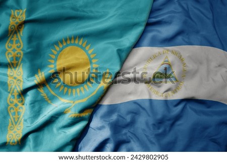 big waving national colorful flag of nicaragua and national flag of kazakhstan. macro
