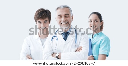 Professional medical team posing together and smiling, healthcare and medical assistance concept, copy space