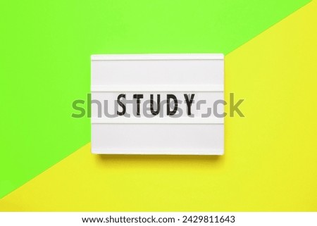 Word STUDY. White lightbox with letters on yellow background.