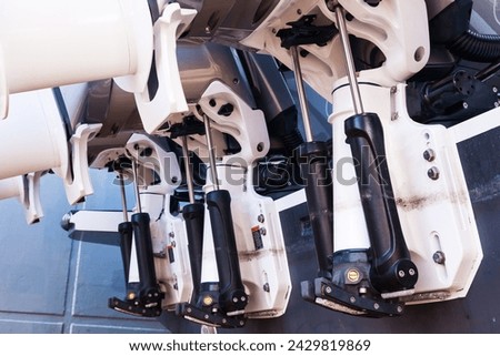 Lifting mechanisms on outboard motors at the stern of the boat. Transom lift on outboard motors of a motor boat. Royalty-Free Stock Photo #2429819869