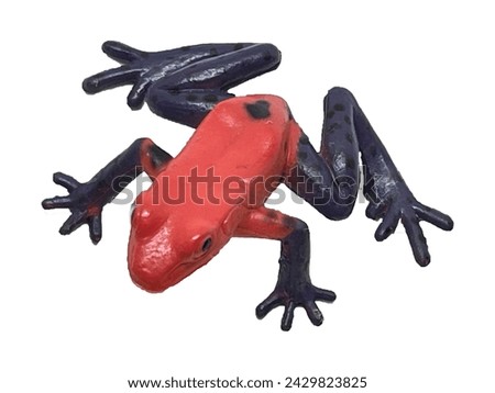 The toy is a red toad with blue spotted paws on a white background. Toad wildlife. Toy one toad view from above
