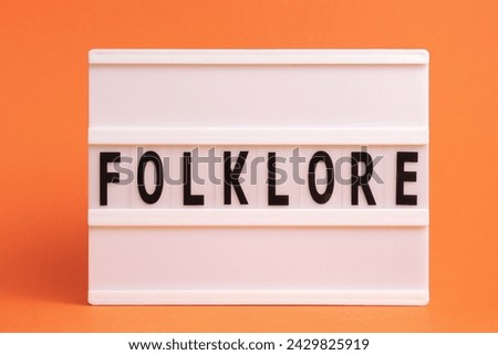 The word folklore on lightbox isolated orange background. Literary Genres