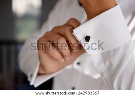 close up of a hand man how wears white shirt and cufflink Royalty-Free Stock Photo #242983567