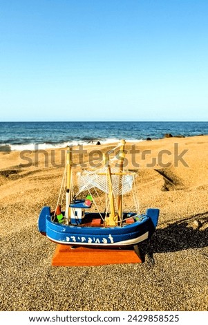 Photo Picture of a Toy Boat on the Sand Beach