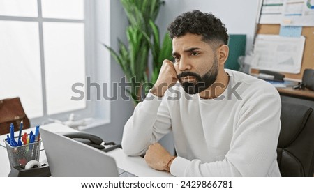 Handsome bearded man contemplating in a bright modern office, exuding a professional yet casual vibe