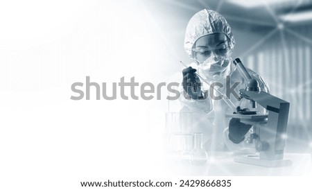 Medical laboratory specialist. Woman doctor with microscope. Doctor immunologist in chemical protection suit. Medic holds test tube. Copy space for laboratory advertising. Doctor virologist at work Royalty-Free Stock Photo #2429866835