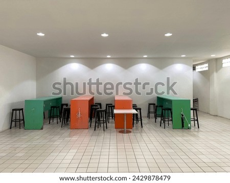 several orange and green cafe tables and chairs inside the supermarket Royalty-Free Stock Photo #2429878479