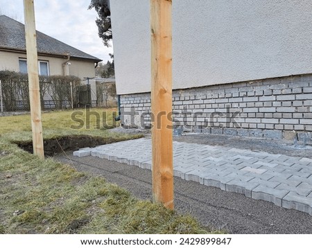 Laying gray concrete paving slabs in house courtyard driveway. Professional work