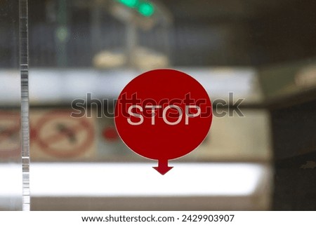 Stop sign is displayed on the glass panel of the escalator.