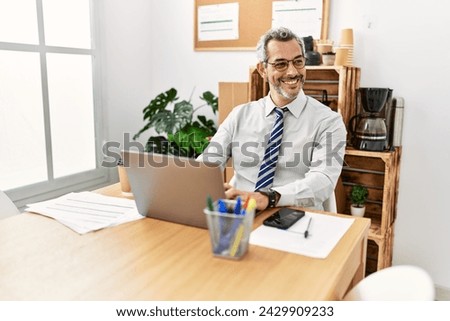 Middle age grey-haired man business worker using laptop working at office