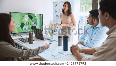 Asian woman lead young group of multiethnic businesspeople in team meeting, using laptop computer for ESG topic presentation on monitor. Sustainable business practice, people work at home concept Royalty-Free Stock Photo #2429975793