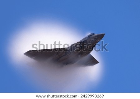 Very unusual close view of a F-35C Lightning II  at very high speed, emerging from a  condensation cone (“singularity”) 