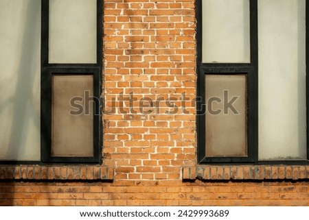 Fragment of the facade of an old brick building. High Windows and textured materials. Architectural background
