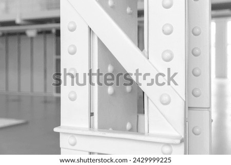 Vintage industrial architecture details, close-up photo of a white steel truss pillar structure