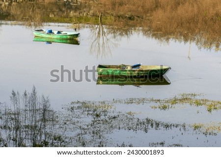 Wooden green colored fishing boat on the lake, reflection of the boat on the water. Authentic wooden boat. Sazlidere Lake, Istanbul, Turkey. Royalty-Free Stock Photo #2430001893