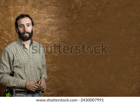 Horizontal photo a confident carpenter stands relaxed in his workshop, with a warm textured wooden background enhancing his professional aura. Copy space. Business concept.