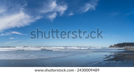 Tropical ocean beach with ocean waves and blue skies and clouds in panoramic format. No data Licensing. Royalty-Free Stock Photo #2430009489