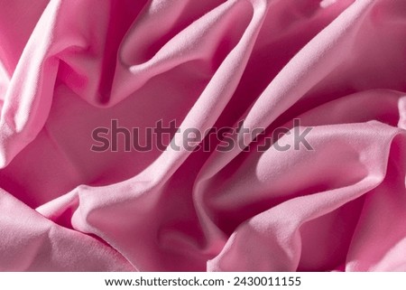 Pink satin fabric background. Top view, flat lay design.