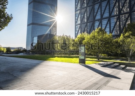 Sunlit City Plaza with Modern Skyscrapers and Trees Royalty-Free Stock Photo #2430015217