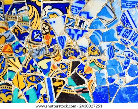 Broken glass mosaic tiles used as ceramic art at Park Guell, Barcelona, Spain. Royalty-Free Stock Photo #2430027251