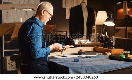 Couturier looking for items to create fashion collection in tailoring workshop, experienced tailor working on clothing line with crafting skills. Small business concept textile industry. Royalty-Free Stock Photo #2430040263