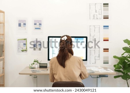 Architectural concept, Behind view female architect working about design house interior on computer.