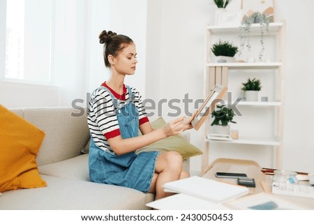 Happy Teenage Girl Artist at Home, Paints a Cute Portrait on Sofa in Modern Indoor Studio