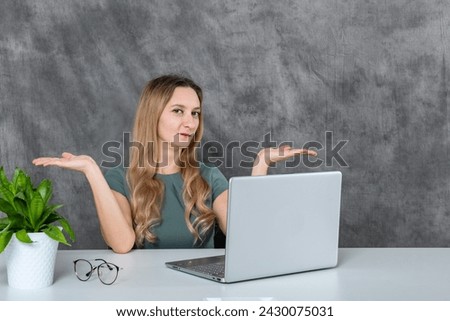 Young woman with blonde hair and gray dress in various poses with laptop and green flower