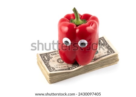 Red bell pepper with eyes on a stack of 1 US dollar bills