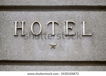 Close-up on a brass 1 star hotel sign.