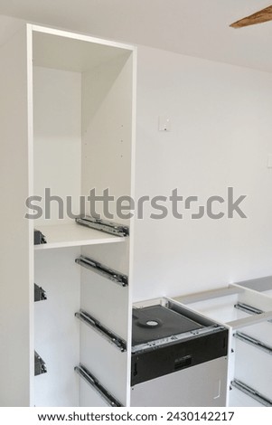 Drawer guide rail, mounted in a new kitchen cabinet. Royalty-Free Stock Photo #2430142217