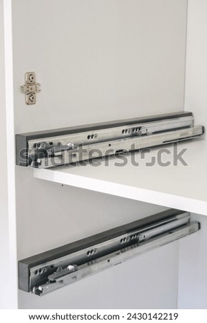 Drawer guide rail, mounted in a new kitchen cabinet. Royalty-Free Stock Photo #2430142219