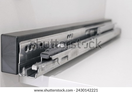 Drawer guide rail, mounted in a new kitchen cabinet. Royalty-Free Stock Photo #2430142221