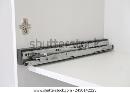 Drawer guide rail, mounted in a new kitchen cabinet. Royalty-Free Stock Photo #2430142223