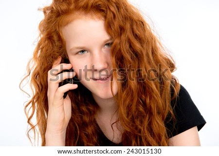 red haired girl is calling with her cell- phone