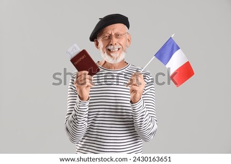 Senior man with flag of France on light background