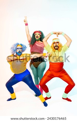 Three crossdressers sport colorful retro attire and strike empowering superhero poses with playful expressions. Royalty-Free Stock Photo #2430176465