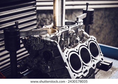 Three-cylinder engine repair on CNC machine, boring under the piston using machine with Computer Numerical Control.  Royalty-Free Stock Photo #2430178035