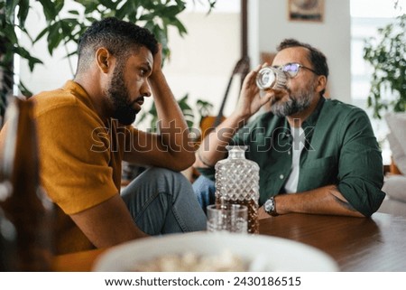 Best friends, supporting each other, drinking whiskey and talking. Discussing problems and drowning sorrows in alcohol. Concept of male friendship, bromance. Royalty-Free Stock Photo #2430186515