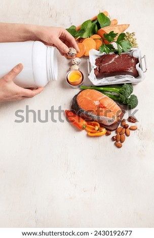 Vitamin A in food, natural products rich in vitamin A as red pepper, parsley leaves, dried apricots, carrots, broccoli, milk, egg yolk and cod liver oil on a light background. Top view. Copy space.